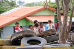 Children playing at tires instead of playground, since playground has no shade and is thus too hot